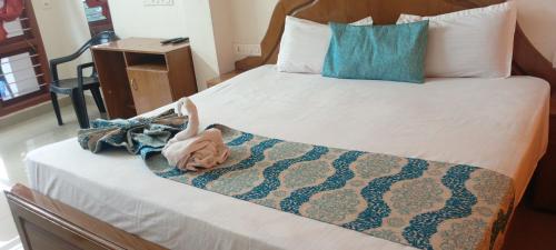 a bed with a blanket and a doll on it at Mattuppavu Beach House in Vilinjam