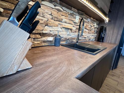a kitchen counter with a sink and a stone wall at Apartmán Horal in Jilemnice
