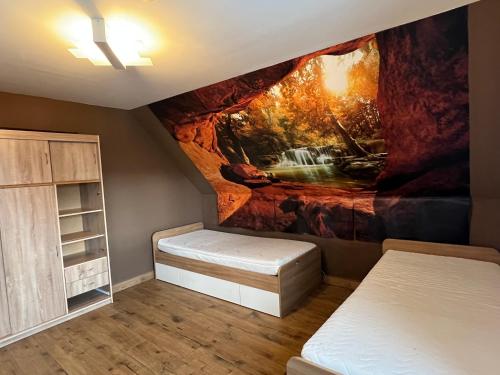 a room with two beds and a painting on the wall at Apartmán Horal in Jilemnice