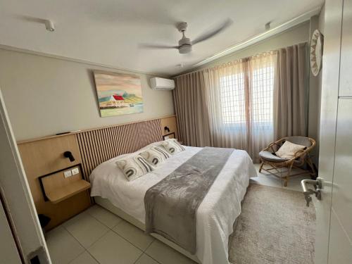 a hotel room with a bed and a chair at Turquoise Bay Beach Apartments Trou d'Eau Douce in Trou d'Eau Douce