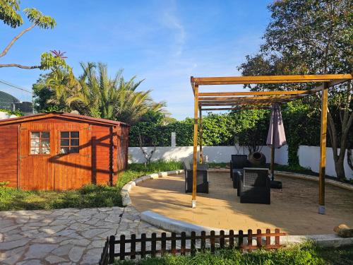 a backyard with a wooden pergola and a house at Blife Sunya private rooms near airport and nature in Faro