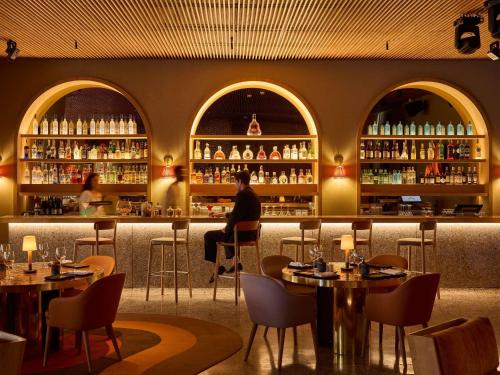 een persoon die aan een bar in een restaurant zit bij Sofitel Agadir Thalassa Sea & Spa in Agadir