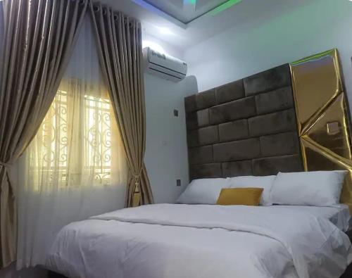a bedroom with a large white bed and a window at Travel Lodge Apartment in Sagisa