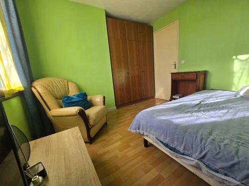 a bedroom with a bed and a chair and a table at The Private House in Paroy