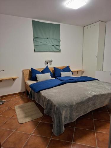 a bedroom with a large bed with blue pillows at Casa Hess in Velden am Wörthersee