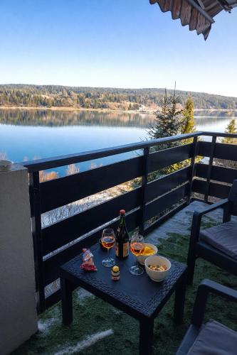 un tavolo con una bottiglia di vino e ciotole di cibo di Refuge du Renard au Bord du Lac a Malbuisson