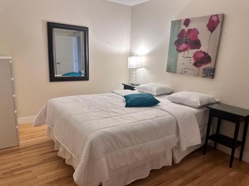 una camera da letto con un letto con un tavolo e uno specchio di Appartement meublé 2ch - Verone 6 a Laval