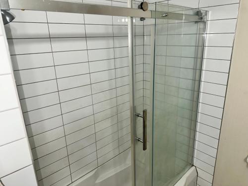 una doccia con una porta in vetro in un bagno di Appartement meublé 2ch - Verone 6 a Laval