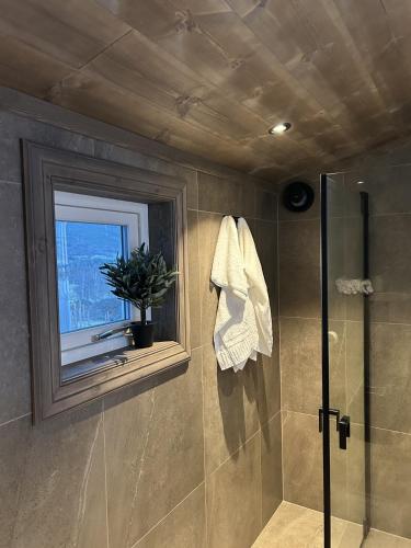 a bathroom with a shower and a window at Fjelleventyret gårdsovernatting in Skjåk