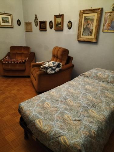 a bedroom with a bed and a chair and a couch at Lara home in Gaglianico