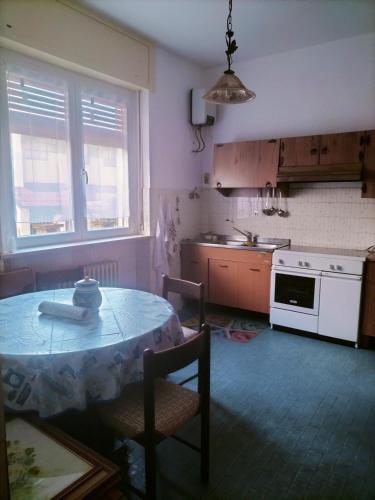 a kitchen with a table and chairs and a table and a stove at Lara home in Gaglianico