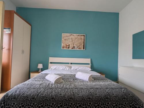 a blue bedroom with a bed with two pillows at Pearl Pisa guest house in Pisa