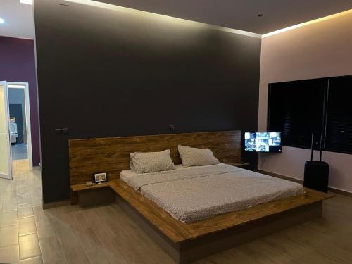 a bedroom with a bed and a flat screen tv at Villa Oasis Antananarivo Private Stay in Antananarivo