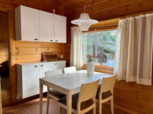 a kitchen with a table and chairs and a window at Loma-aika in Vierumäki