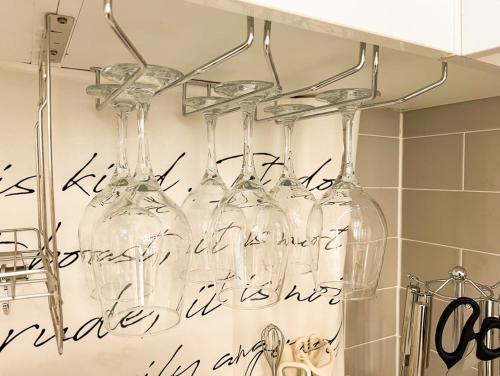 four wine glasses hanging on a rack in a kitchen at 스테이 느릿 in Seoul