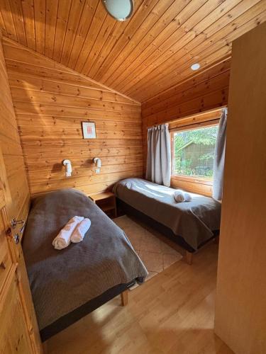 a room with two beds in a log cabin at Loma-aika in Vierumäki