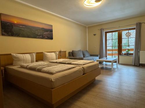 a bedroom with a large bed and a couch at Pension Ostrauer Mühle in Bad Schandau