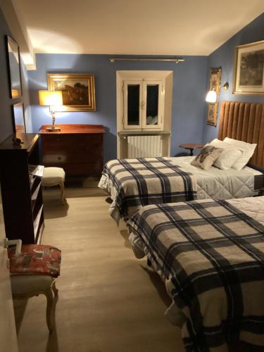 una camera da letto con due letti, un tavolo e una scrivania di La Dimora di Luca a Bientina