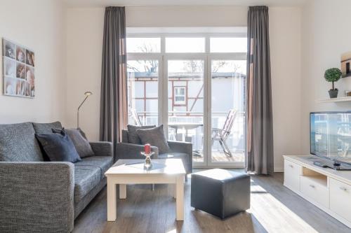 a living room with a couch and a tv at Villa Marin, Wohnung 16 in Zinnowitz