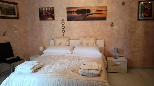 una camera da letto con un letto con asciugamani sopra di Appartamento centro storico quartiere San Michele a Sciacca