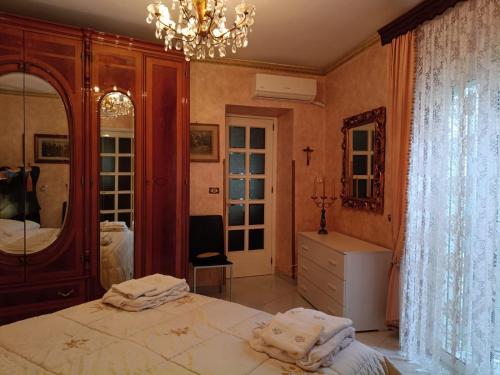 una camera da letto con un letto grande e un lampadario di Appartamento centro storico quartiere San Michele a Sciacca