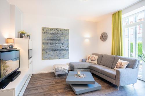 een woonkamer met een bank en een tv bij Villa Marin Wohnung 04 in Zinnowitz