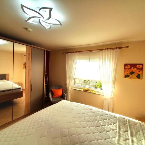 a bedroom with a white bed and a window at FeWo Sonnenblume mit sauna in Daun