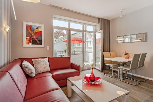 a living room with a red couch and a table at Villa Marin, Wohnung 14 in Zinnowitz