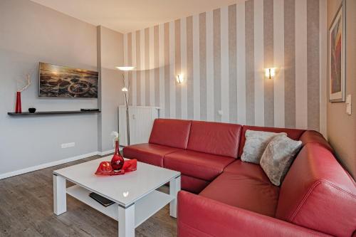a living room with a red couch and a table at Villa Marin, Wohnung 14 in Zinnowitz
