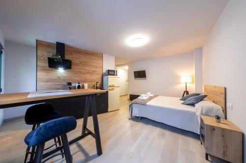 een slaapkamer met een bed en een bureau en een bed en een keuken bij Apartamentos muralla de Lugo in Lugo