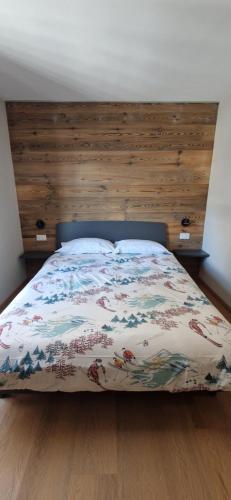 a bedroom with a bed with a wooden headboard at Valtour House in Valtournenche