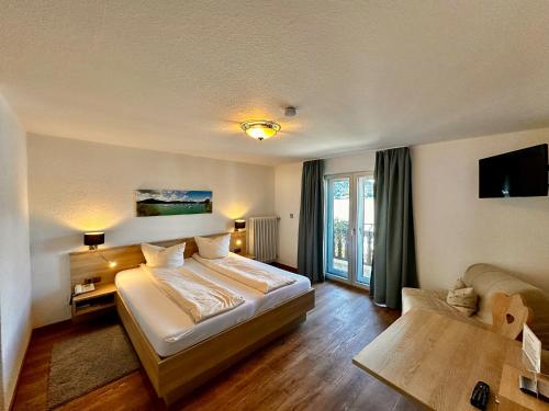 a hotel room with a bed and a window at Hotel Fischerstüberl am See in Tegernsee