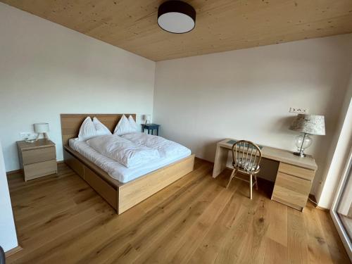 una camera da letto con un letto, una scrivania e una sedia di Apartment Laura a Jenig