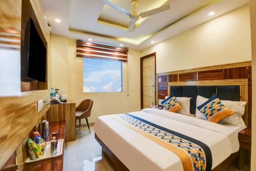 a bedroom with a bed and a desk and a television at Hotel Ruhi Dx - Near New Delhi Railway Station & Connaught Place in New Delhi