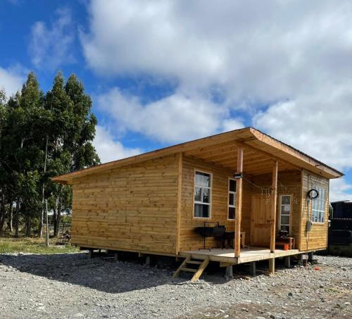 een klein houten schuurtje met een veranda en een hemel bij CABAÑA ORO RAYADO PUERTO MONtt in Puerto Montt