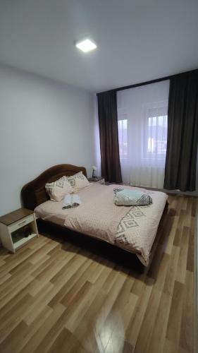 ein Schlafzimmer mit einem Bett und einem Holzboden in der Unterkunft Nikolas apartment in Mitrovica