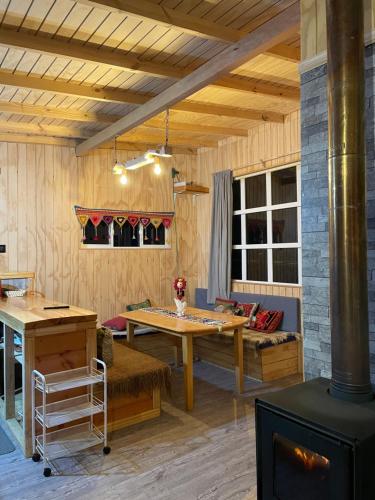 een woonkamer met een tafel en een fornuis bij CABAÑA ORO RAYADO PUERTO MONtt in Puerto Montt
