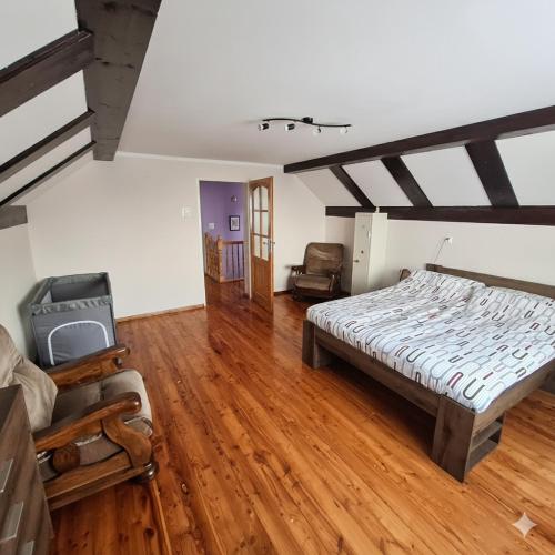 a bedroom with a bed and a wooden floor at Agroturystyka u Janosika in Bozkow