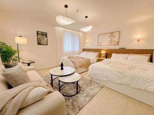 a hotel room with two beds and a couch at 스테이 느릿 in Seoul