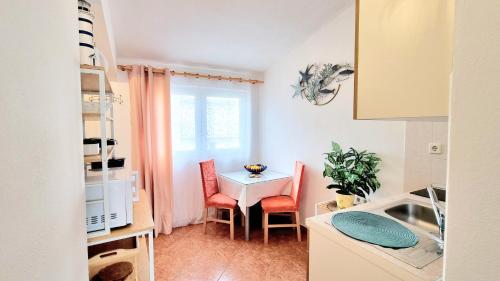 een keuken en eetkamer met een tafel en stoelen bij Apartmani Skoric Fanatic in Primošten