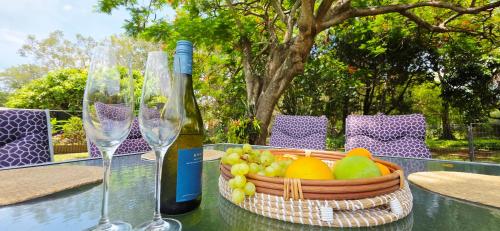 a basket of fruit and a bottle of wine on a table at Family Cozy House near the Bay and the Reserve in Golden Beach