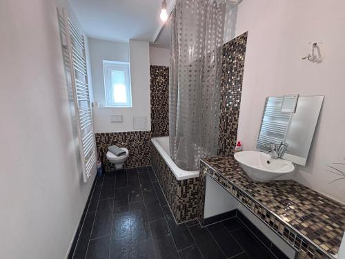 un bagno con lavandino, vasca e WC di Spacious Flat with 3 bedooms for 5-8 guests a Zeitz