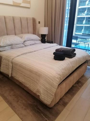 a large bed in a bedroom with a lamp at Chic Studio - Luxury Comfort - Dereva Stays in Dubai