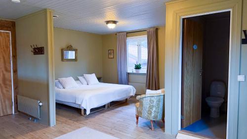 een slaapkamer met een wit bed en een raam bij Bredsjö Herrgård in Hällefors