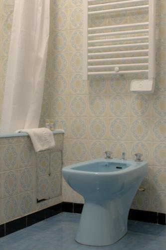 a bathroom with a toilet and a window and a shower at Hôtel Restaurant Sole e Monte in Cuttoli-Corticchiato