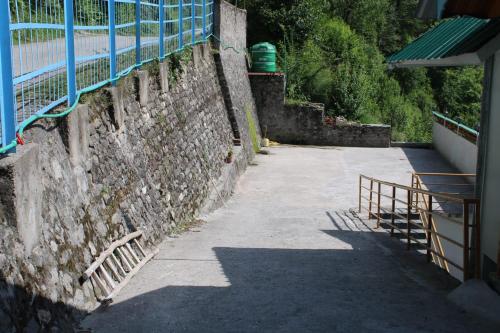 a stone wall with a fence next to a sidewalk at Maverick HomeStay in Baragrān