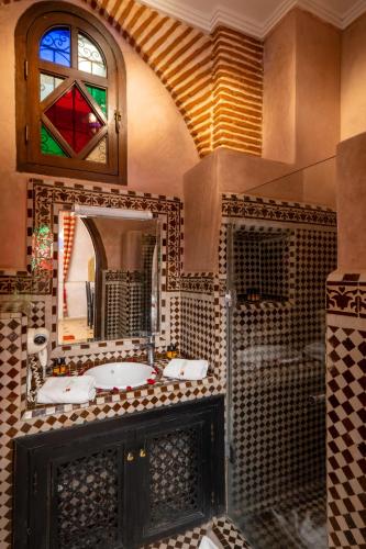a bathroom with a sink and a mirror at Riad Mabrouk in Marrakesh