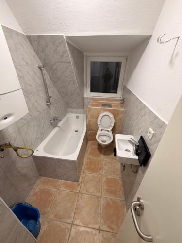 a bathroom with a tub and a toilet and a sink at Workhome A2 zu 6 in Lünen