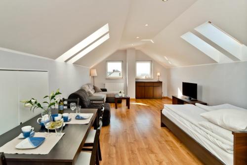 ein Wohnzimmer mit einem Bett und einem Esstisch in der Unterkunft HORN Jastarnia in Jastarnia