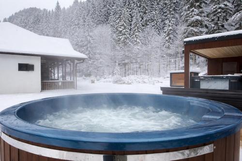 una vasca idromassaggio nella neve con gazebo di Lacu Roșu Mountain Lodge a Lacu Rosu